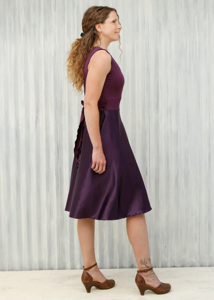 purple dress with black heels Young woman wearing a short purple dress and high heels, posing, leaning against a grey wall Stock Photo